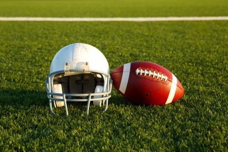 American football and helmet on the field