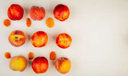 Top view of pattern of sliced and whole peaches on left side and white background with copy space Stock Photo