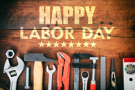 Happy labor day text and construction tools on wooden table top view united states america holiday celebration