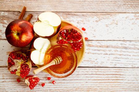 Apples pomegranate and honey on a wooden background traditional jewish food new year rosh hashanah