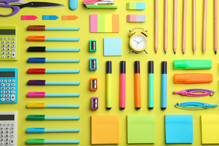 Flat lay composition with school stationery on yellow background back to school