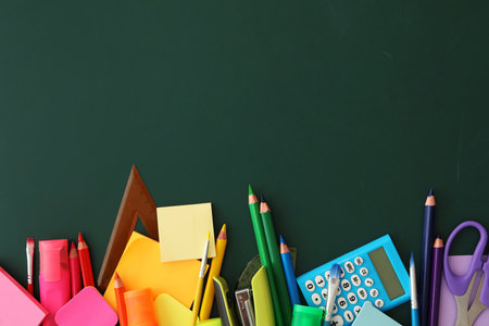 Flat lay composition with different school stationery on green chalkboard space for text back to school Stock Photo