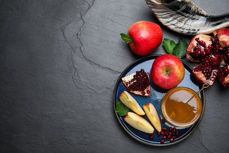 Honey pomegranate apples and shofar on black table flat lay with space for text rosh hashanah holiday Stock Photo