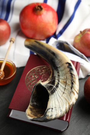 Shofar and book torah with text in hebrew on black table closeup rosh hashanah celebration Stock Photo