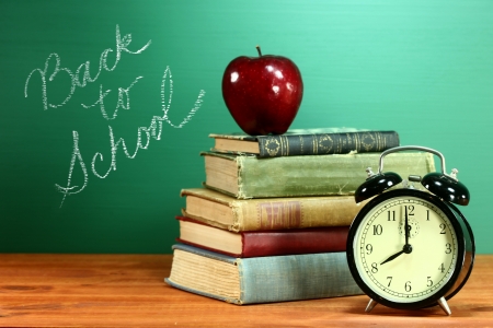 Back to school books apple and clock on desk