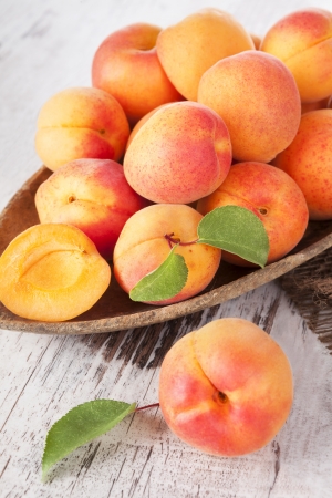 Fresh apricots on wooden spoon on white wooden background healthy fresh fruit eating