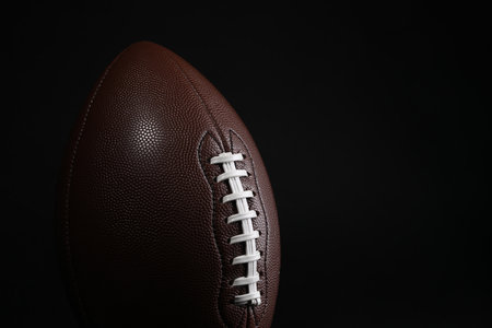 American football ball on black background closeup space for text Stock Photo