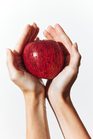 Hands holding a red apple on a white background Stock Photo