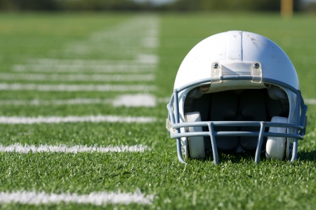 American football helmet on the field with room for copy