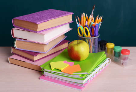 School supplies on table on board background