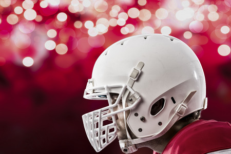 Close up of a football player with a red uniform on a red lights background Stock Photo