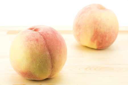 One peach and one blur peach on wood board Stock Photo