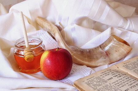 Rosh hashanah jewesh holiday concept shofar torah book honey apple and pomegranate over wooden table traditional holiday symbols