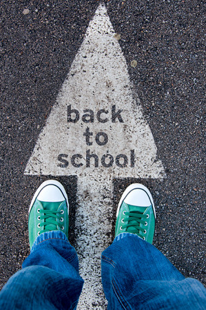 Student standing above the sign back to school