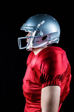 Side view of sportsman standing against black background Stock Photo