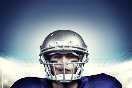 Portrait of determined american football player in uniform against rugby stadium Stock Photo