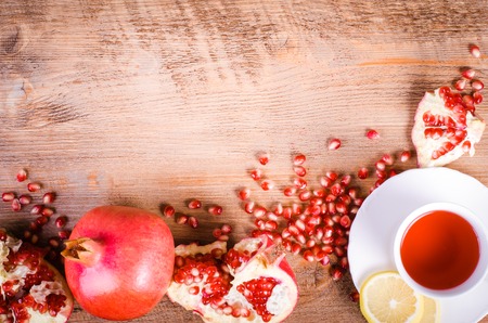 Fresh pomegranate seeds and cup of hibiscus tea on wooden background Stock Photo