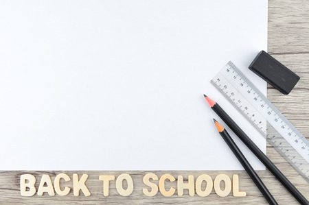 Pencil eraser and ruler with blank paper on wooden background back to school concept