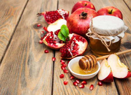 Honey with pomegranate and apples on a old wooden background Stock Photo