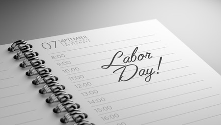 Closeup of a personal calendar setting an important date representing a time schedule the words labor day written on a white notebook to remind you an important appointment