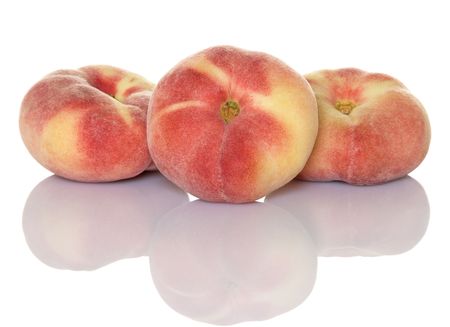 Three saturn peaches isolated with reflection Stock Photo