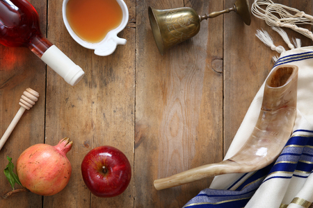 Rosh hashanah jewish new year holiday concept shofar horn honey apple and pomegranate over wooden table traditional symbols