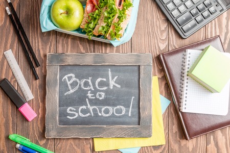 School lunch with sandwich milk and apple on dark background