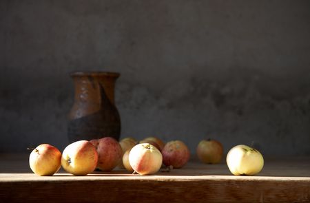 Apples and clay jug on a table