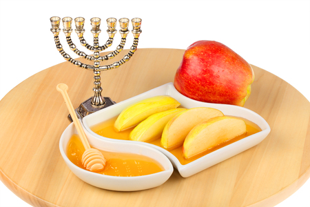 Apples and dipping slices of apple in honey for rosh hashanah the jewish new year