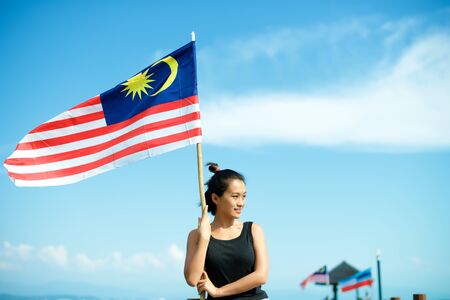 Girl on pier on sabah island with malaysian flag