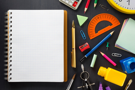 School supplies on black wooden background