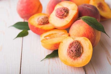 A lot of fresh peaches on a white table