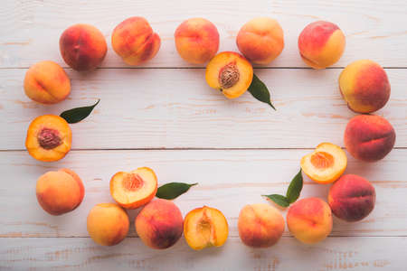 A lot of fresh peaches on a white table