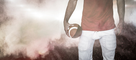 3d midsection of a rugby player holding ball against splashing of powder Stock Photo