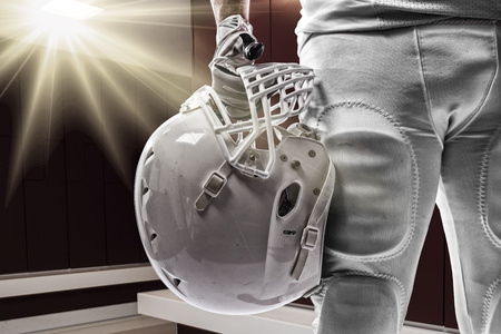 Football player with a white uniform on a locker roon