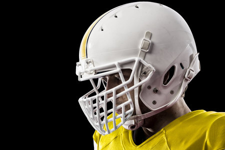 Close up of a football player with a yellow uniform on a black background