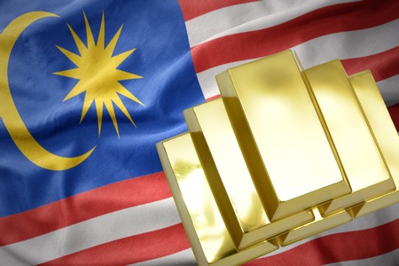 Gold reserves shining golden bullions on the malaysia flag background