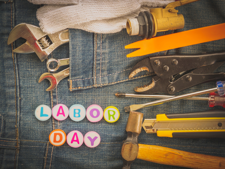 Labor day background concept jeans many handy tools with labor day text on jeans background top view