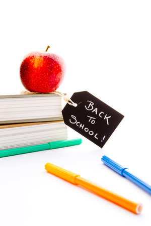 Back to school red apple books and pens with blackboard handwritten chalk label