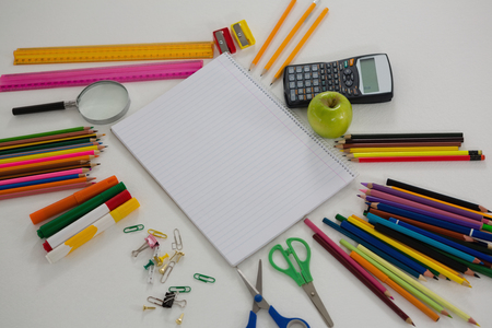 Close up of various school supplies arranged on white background