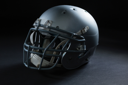 Close up of american football head gear on a black background