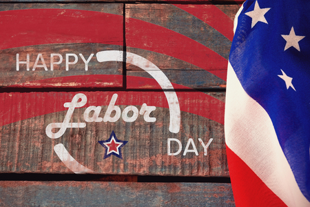 Digitally generated image of happy labor day banner against american flag on a wooden table Stock Photo