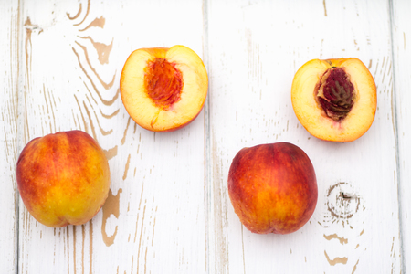 A lot of fresh peaches on a white table top view Stock Photo