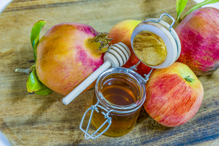 Honey apples and pomegranates on wood deck for rosh hashana celebration honey garnet apples jewish new year