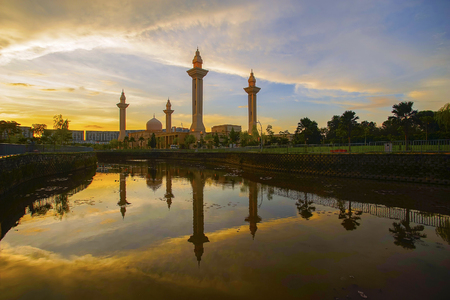 Beautiful sunset scenery and a reflection of majestic mosque in a lake