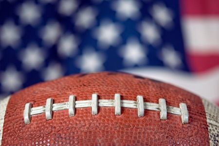 Extreme close up of a football with flag background