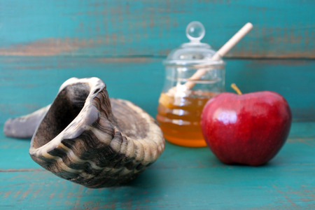 Shofar honey jar and red apple on a turquoise background rosh hashanah jewish new year holiday concept copy space