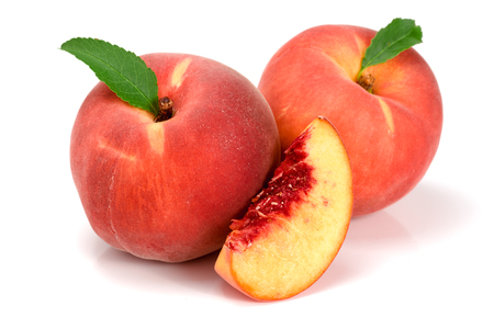 Peaches and slice with a green leaf isolated on white background