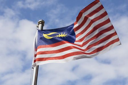 Malaysia flag also known as jalur gemilang wave with the blue sky people fly the flag in conjunction with the independence day celebration or merdeka day Stock Photo