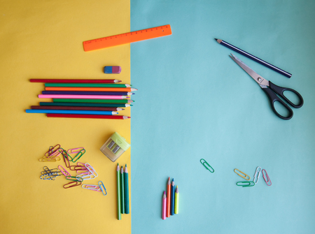 Scissors colored pencils ruler rubber band on the table